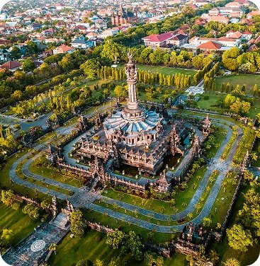 Aerial view of the majestic Bajra Sandhi Monument in Renon, Denpasar, Bali, a symbol of Balinese struggle, set within lush green parklands and urban surroundings.